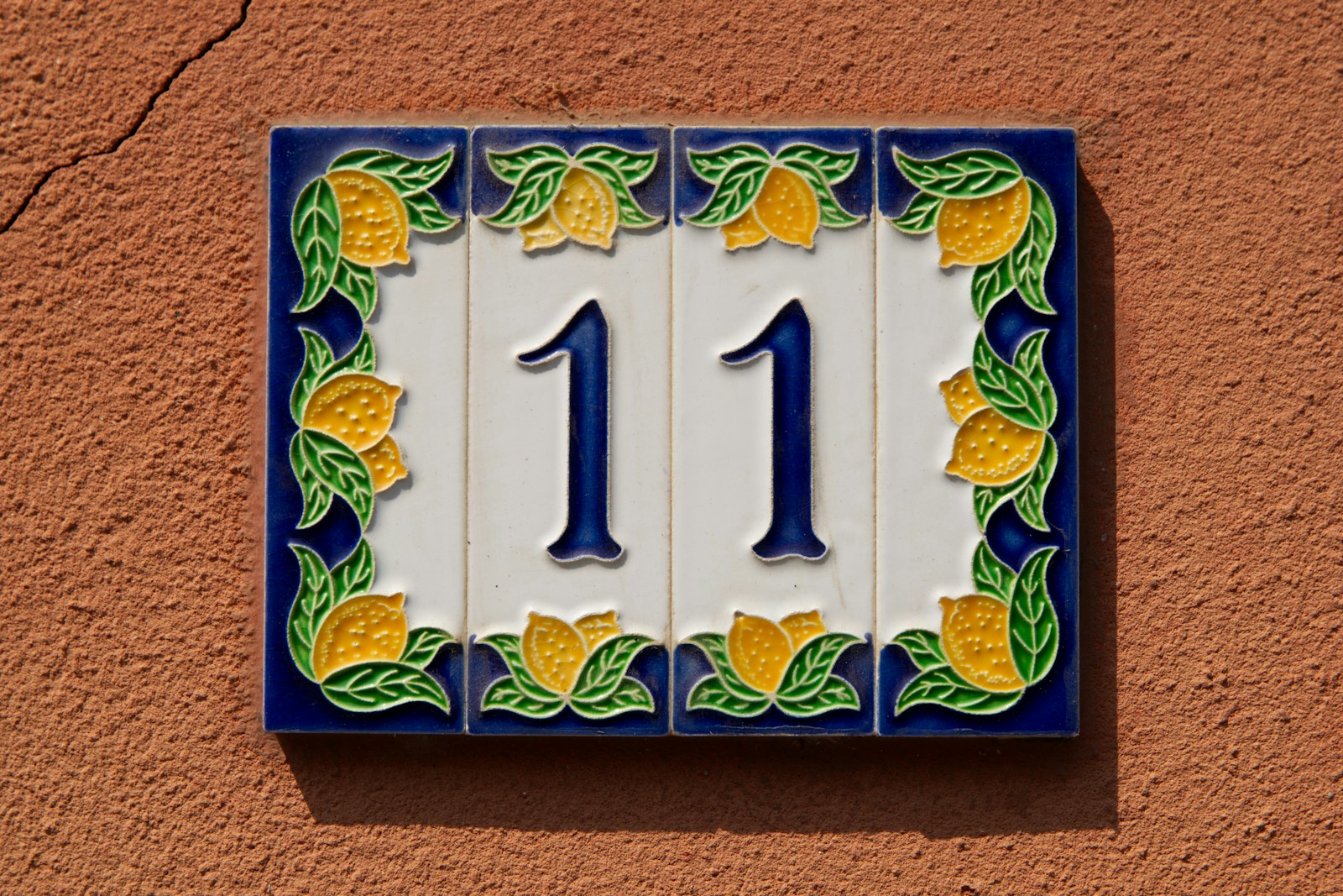 A blue and yellow house number 11 on a wall