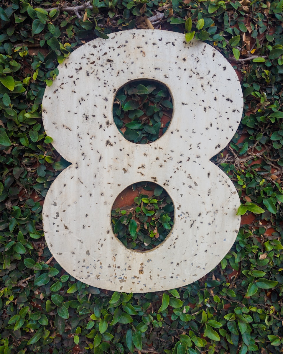 A large number eight against green foliage